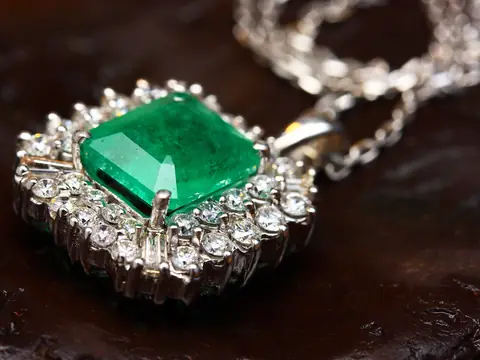 An emerald pendant framed in diamonds on a white gold chain