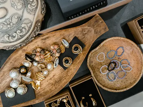 Rings, pearls and earrings sorted into wooden dishes and boxes