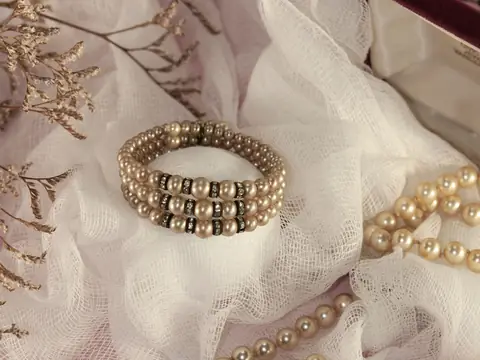 A vintage pearl bracelet and pearl necklace on white tulle
